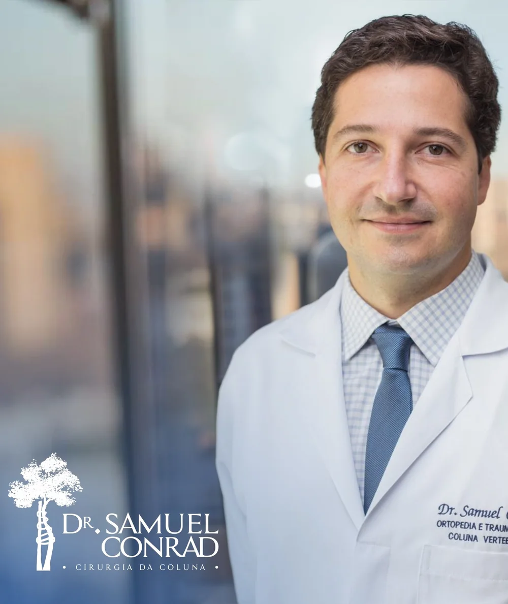 Dr. Samuel Conrad de jaleco, sorrindo, em frente a uma janela